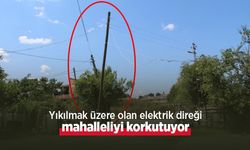 Yıkılmak üzere olan elektrik direği mahalleliyi korkutuyor
