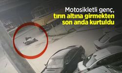Motosikletli genç, tırın altına girmekten son anda kurtuldu
