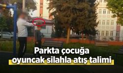 Parkta çocuğa oyuncak silahla atış talimi