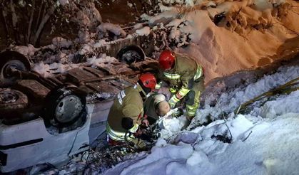 Karlı yolda sulama kanalına düşen otomobil ters döndü