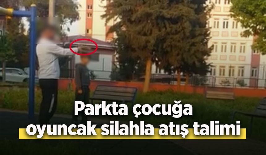 Parkta çocuğa oyuncak silahla atış talimi